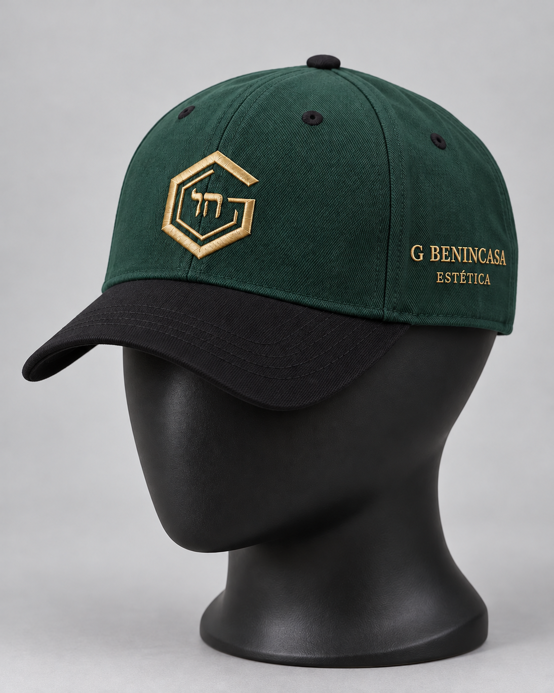 Forest-green cap with black brim on a matte-black display form; planned gold G and Chai front embroidery and G Benincasa Estética side lettering.